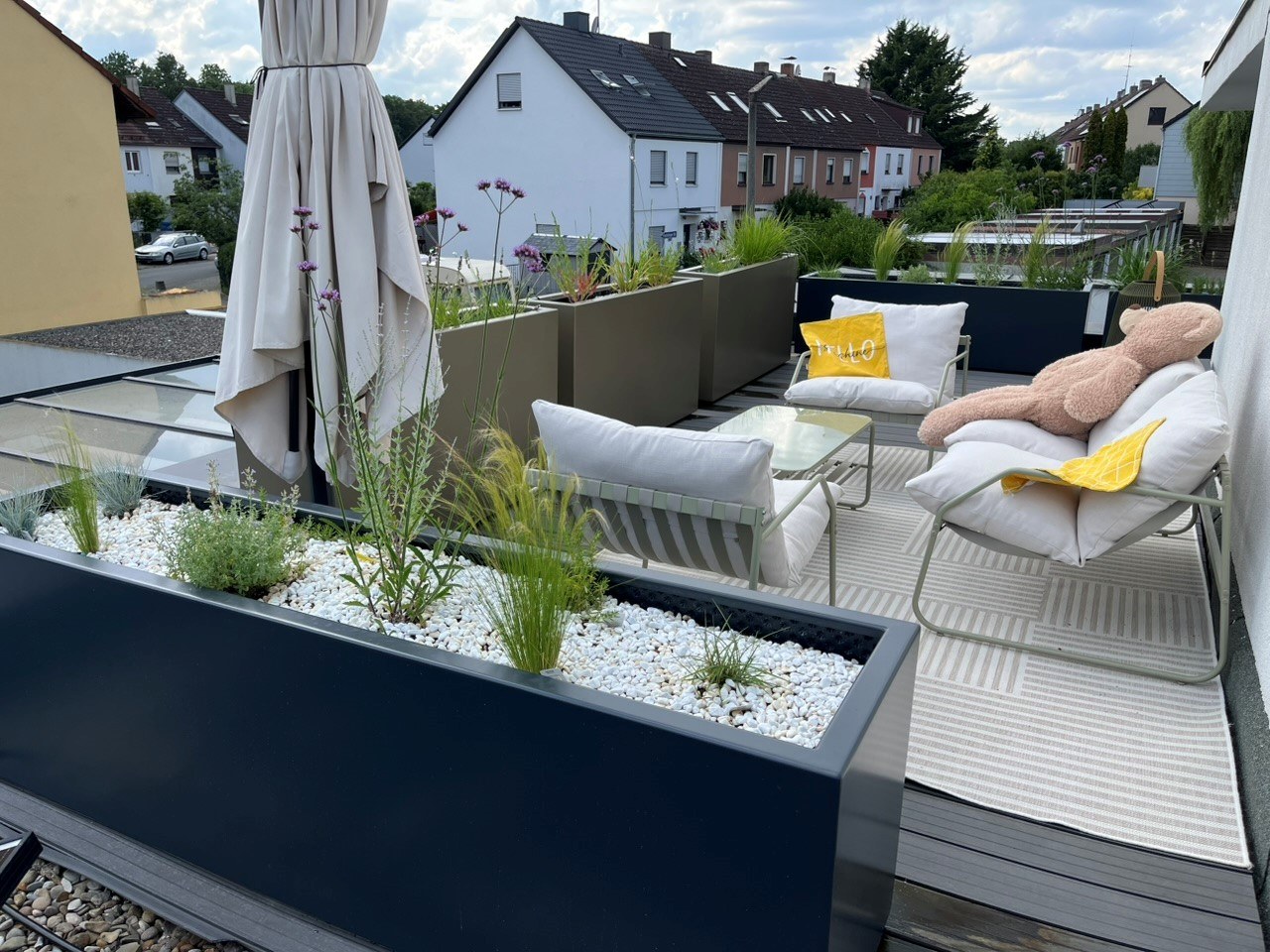 Beispiel einer sehr gelungenen Dachterrassengestaltung in Fürth mit OOLEX HONES Pflanzgefäßen mit Boden. RAL Farbe 1035 und 7016 in Kombination.