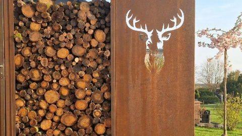 Holzlager cortenstahl und sichtschutz mit hirschkopf